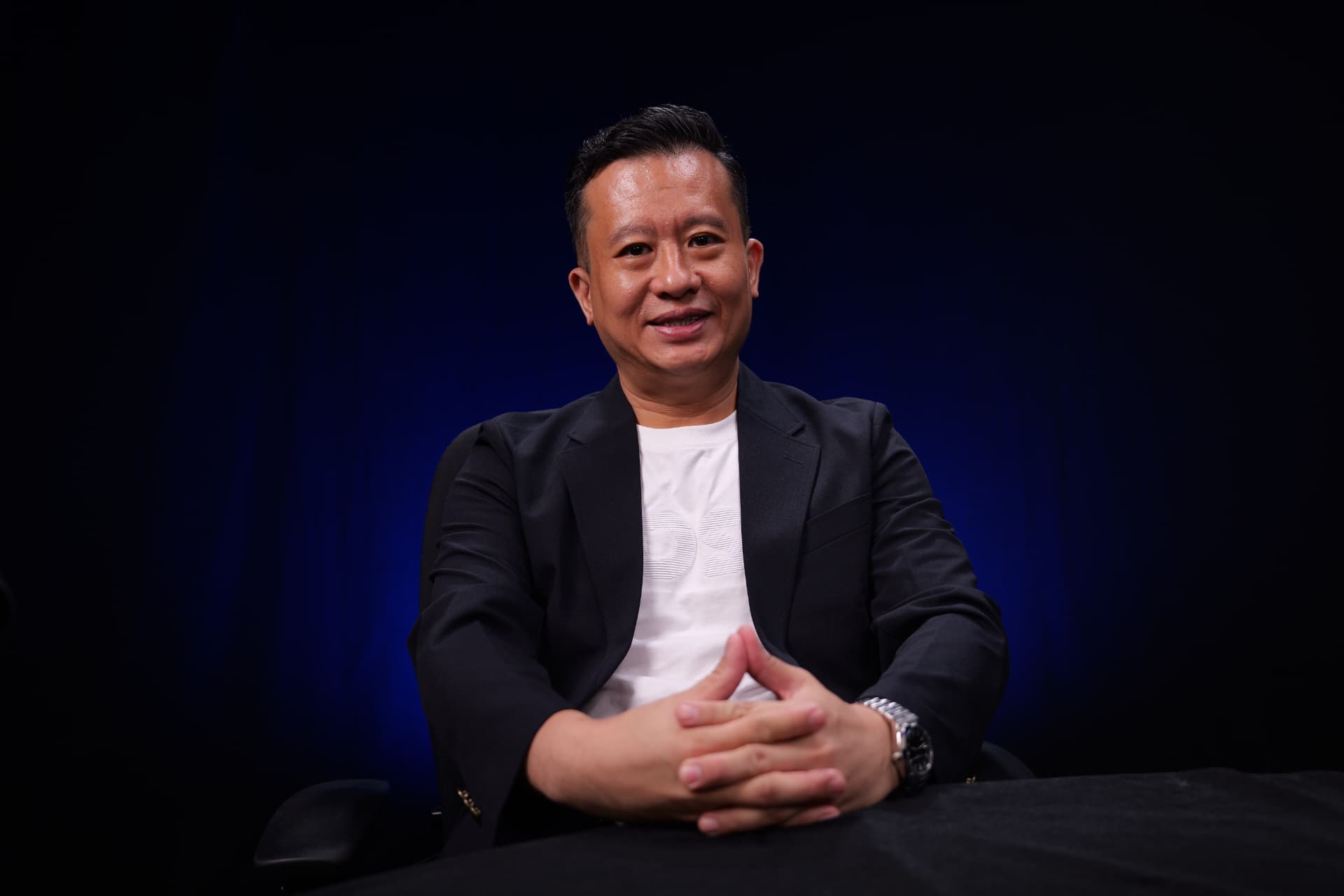 MC Gan, prime-district Singapore property specialist, seated with hands clasped